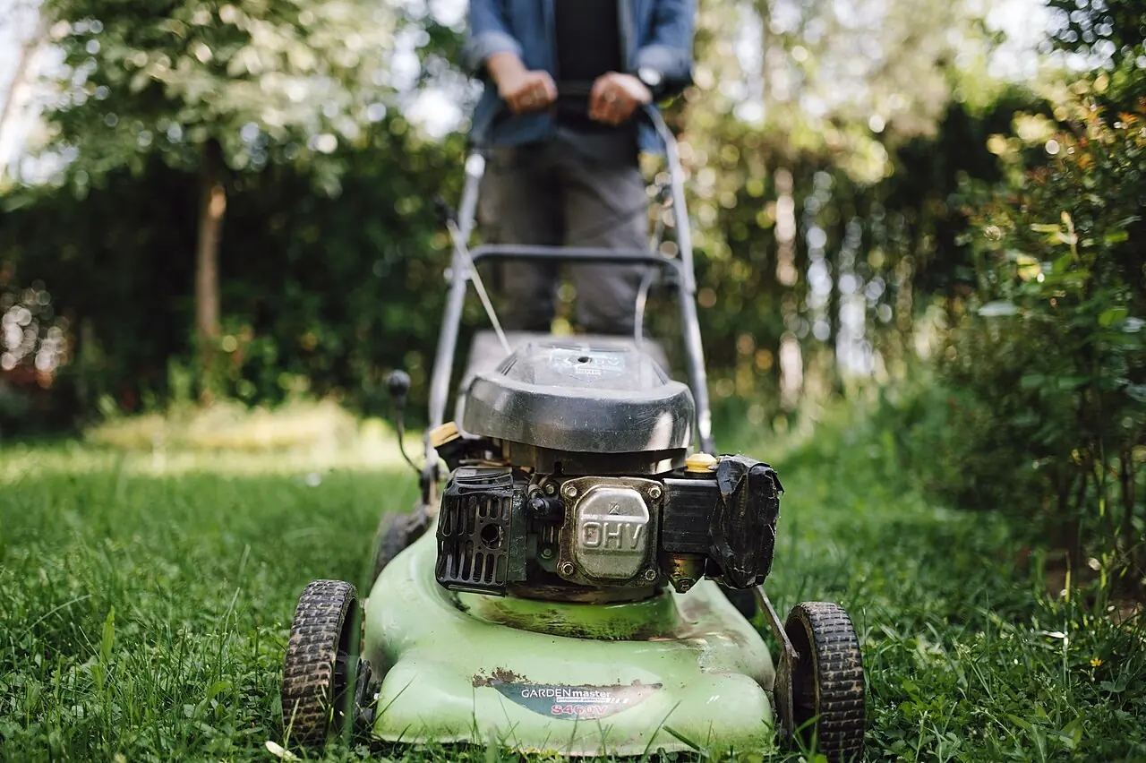 A person mowing a residential lawn.